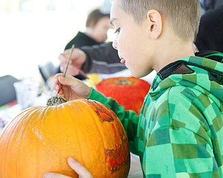 Mason Salensky, 7, of Struthers, paints a pumpkin at Parto's Golf Learning Center's annual children's Halloween party on Saturday. EMILY MATTHEWS | THE VINDICATOR
