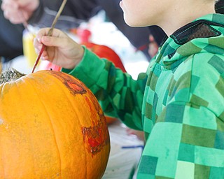 Mason Salensky, 7, of Struthers, paints a pumpkin at Parto's Golf Learning Center's annual children's Halloween party on Saturday. EMILY MATTHEWS | THE VINDICATOR