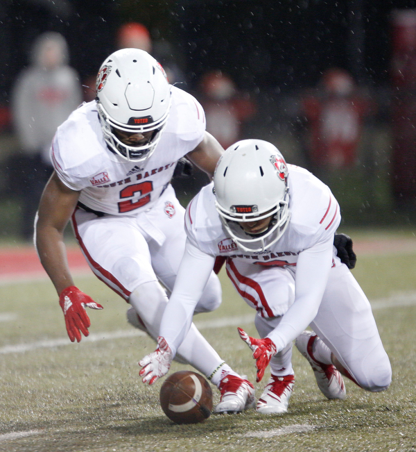 South Dakota's Kai Henry, left, and Trystn Ducker go after the ball during the first half of their game against Youngstown State at Stambaugh Stadium on Saturday. EMILY MATTHEWS | THE VINDICATOR