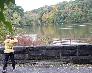 Juel Fitzgerald, of Cleveland, stops running to take a picture of Lake Glacier during the Youngstown Peace Race 10K on Sunday morning. EMILY MATTHEWS | THE VINDICATOR