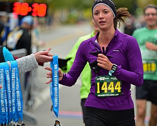 YOUNGTSOWN, OHIO - OCTOBER 21, 2018: Katelynn Morrell is handed a medal after crossing the finish line and completing the 2018 Peace Race, Sunday morning in Youngstown. DAVID DERMER | THE VINDICATOR