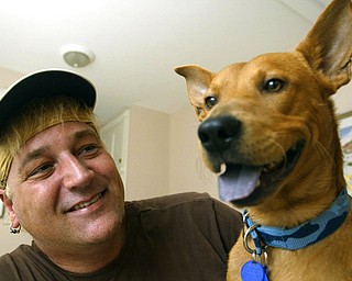This Aug. 13, 2003, photo shows Quentin, right, with his new owner Randy Grim at his south St. Louis home. Quentin, who gained attention 14 years ago when he emerged alive from a St. Louis gas chamber for strays, has died. Quentin's death was announced Sunday by his owner, Grim, founder of Stray Rescue of St. Louis. The mixed-breed dog had suffered a stroke.