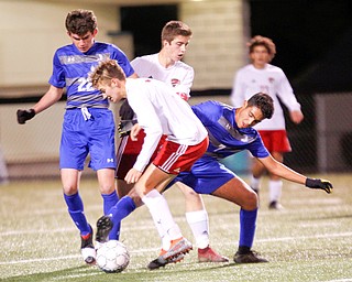 Canfield's Aren Villano, 7, front, and Mitch Mangle, 24, back, surround Hubbard's Nader Kassem, 7, right, as he goes for the ball with help from Hubbard's Jacob Gulu, 22, left, during their game at Hubbard on Tuesday night. EMILY MATTHEWS | THE VINDICATOR