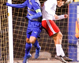 Hubbard's Nikolas Dowell jumps as Canfield's Mike Mecure heads the ball during their game at Hubbard on Tuesday night. EMILY MATTHEWS | THE VINDICATOR