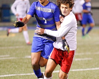 Hubbard's Nader Kassem and Canfield's Mike Mecure try to get the ball away from each other during their game at Hubbard on Tuesday night. EMILY MATTHEWS | THE VINDICATOR