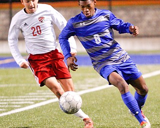 Hubbard's Derrick Cobbin gets ready to kick the ball with Canfield's Nick Hortman close behind him during their game at Hubbard on Tuesday night. EMILY MATTHEWS | THE VINDICATOR