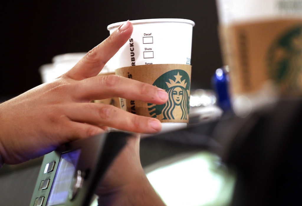 In this May 29, 2018, file photo, a barista reaches for an empty cup at a Starbucks in the Pike Place Market in Seattle. Starbucks has opened its first U.S. “signing store” to better serve hard of hearing customers. The store in Washington, D.C. is just blocks from Galludet Univerisity, one of the nation’s oldest universities serving deaf and hard-of-hearing students.
