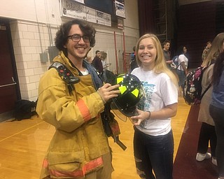 Neighbors | Submitted.Boardman High School senior Joe McKinney tried on Boardman Fire Department gear with the help of YES Fest volunteer Alyssa Berardi on Oct. 19.