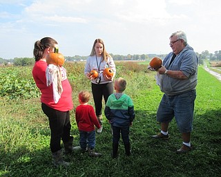 Neighbors | Jessica Harker .Metro Park Farms employee David helped community members wipe mud off their pumpkins Oct. 6 at the Pick a Pumpkin event.