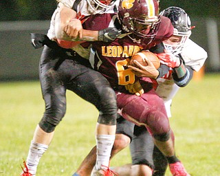 Girard's Aidan Warga, left, and Marco Donatelli tackle Liberty's Migel Burgess during the first half of their game at Liberty on Friday night. EMILY MATTHEWS | THE VINDICATOR