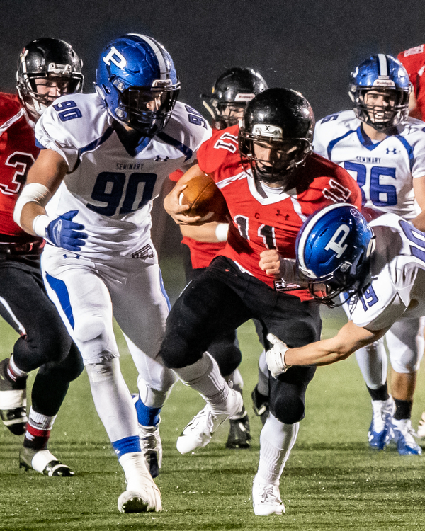 DIANNA OATRIDGE | THE VINDICATOR  Canfield's Max Dawson (11) eludes Poland defenders Scott Campbell (90) and Hayden Kaschak (19) to gain yardage during their game at Bob Dove Field in Canfield on Friday.