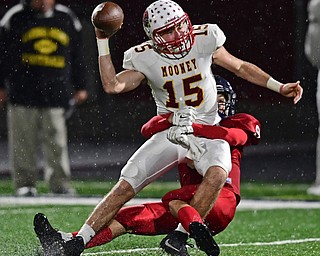 AUSTINTOWN, OHIO - OCTOBER 26, 2018: Mooney's John Murphy looks to throw a pass while being brought down by Fitch's Nate Leskovac during the first half of their game, Friday night at Austintown Fitch High School. DAVID DERMER | THE VINDICATOR