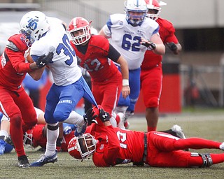 Indiana State's Titus McCoy gets tackled by YSU's Devanere Crenshaw, left, and Avery Larking, 15, during their game at Stambaugh Stadium on Saturday. EMILY MATTHEWS | THE VINDICATOR