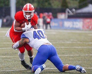 YSU's Christian Turner gets tackled by Indiana State's Katrell Moss during their game at Stambaugh Stadium on Saturday. EMILY MATTHEWS | THE VINDICATOR