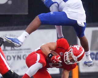 Indiana State's Nehemiah Montague jumps over YSU's Joe Alessi after he's tackled during their game at Stambaugh Stadium on Saturday. EMILY MATTHEWS | THE VINDICATOR