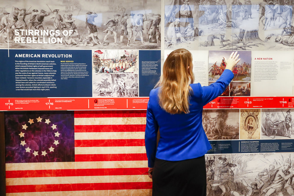 A staff member browses a display during a limited media availability at the National Veterans Museum and Memorial, Monday, Oct. 15, 2018, in Columbus, Ohio. A sweeping new museum in America's heartland honors the unifying experiences of U.S. military veterans outside the traditional trappings of military museums and war memorials. The 50,000-square-foot museum, which opened Saturday, aims to honor, inspire, connect and educate with unique interactive experiences.