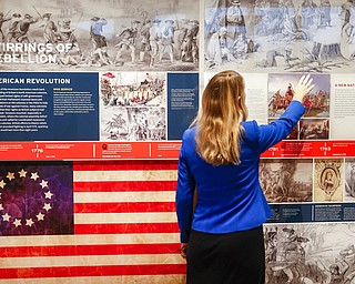 A staff member browses a display during a limited media availability at the National Veterans Museum and Memorial, Monday, Oct. 15, 2018, in Columbus, Ohio. A sweeping new museum in America's heartland honors the unifying experiences of U.S. military veterans outside the traditional trappings of military museums and war memorials. The 50,000-square-foot museum, which opened Saturday, aims to honor, inspire, connect and educate with unique interactive experiences.