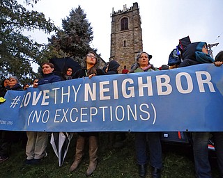 A group holds a sign at the intersection of Murray and Forbes avenues in the Squirrel Hill section of Pittsburgh during a memorial vigil for the victims of the shooting at the Tree of Life Synagogue where a shooter opened fire, killing multiple people and wounding others, including several police officers, Saturday, Oct. 27, 2018.