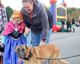 Madison Thoresen, 4, left, dressed as Ana from Frozen, and her mom Jen Thoresen, both of Youngstown, pet Mercy, a nine-year-old Belgian Malinois police dog, during the trick or treat event at Covelli Centre on Tuesday. Mercy will be retiring from duty at the end of November. EMILY MATTHEWS | THE VINDICATOR