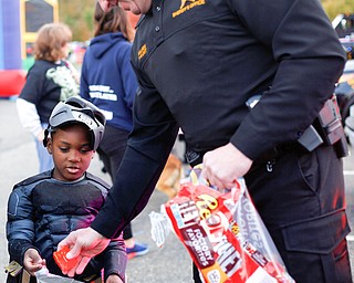 Traylea Smith, 6, dressed as Batman, of Youngstown, gets candy from Deputy Jeff Saluga during the trick or treat event at Covelli Centre on Tuesday. EMILY MATTHEWS | THE VINDICATOR