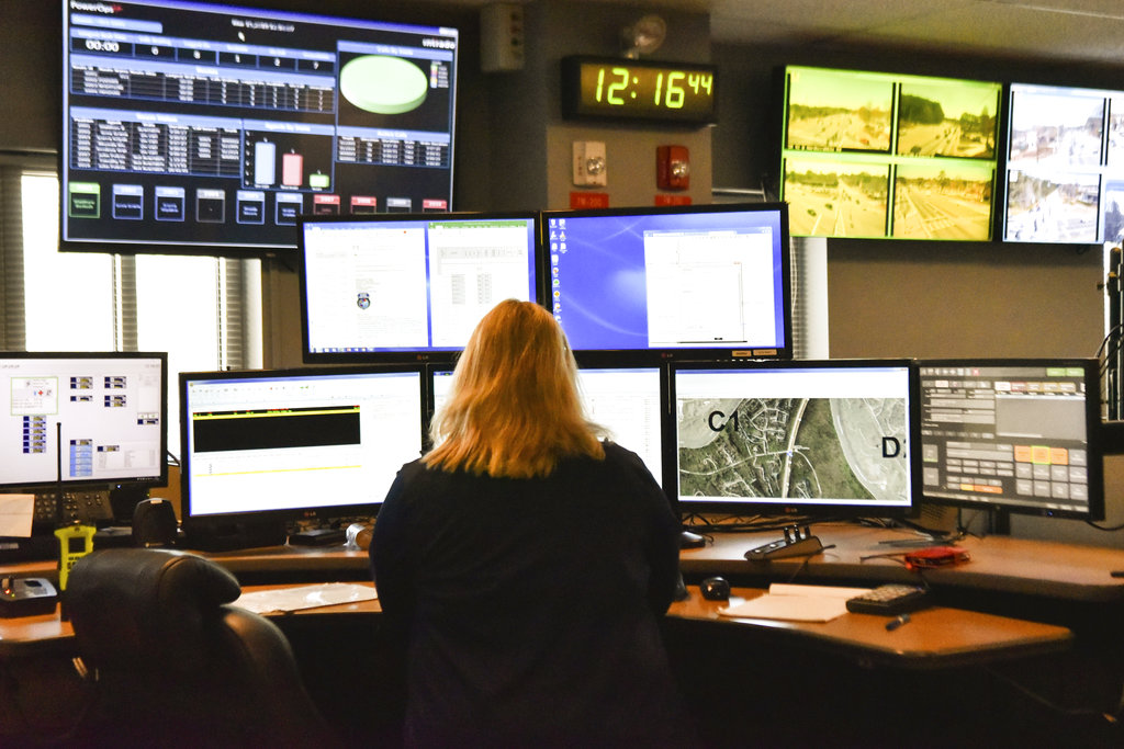 In this March 15, 2018, file photo a dispatcher works at a desk station with a variety of screens used by those who take 911 emergency calls in Roswell, Ga. The Roswell call center is one of the few in the United States that accepts text messages. Most places in the U.S. don’t have access to text-to-911 services, an increasingly crucial gap during an era of mass shootings and other catastrophes, when a phone call is not always an option.