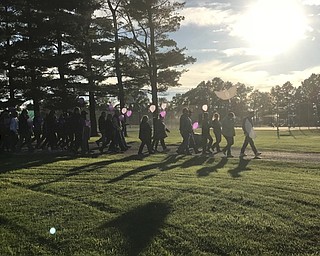 Neighbors | Jessica Harker .Lauren Bowman's family led the walk around Austintown park Oct. 15 carrying dove balloons, separate from the rest of the community members gathered holding purple baloons.