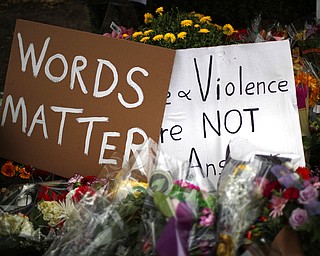 Flowers surround signs on Wednesday, Oct. 31, 2018, at part of a makeshift memorial outside the Tree of Life Synagogue to the 11 people killed during worship services Saturday Oct. 27, 2018, in Pittsburgh.