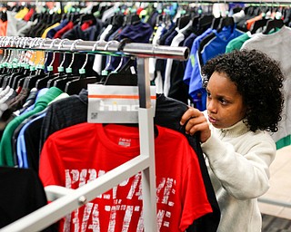 Landen Fitzgerald-Green, 8, looks at shirts in the Burlington store in Boardman during a shopping spree his family received to celebrate his recovery from Leukemia on Thursday. EMILY MATTHEWS | THE VINDICATOR