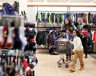 Landen Fitzgerald-Green, 8, walks toward the shoes with his sister Herlo Fitzgerald-Green, 16 months, his mom Lisa Fitzgerald-Green, and Lindsay Silverstein, the Executive Director of the Leukemia and Lymphoma Society, in the Burlington store in Boardman during a shopping spree his family received to celebrate his recovery from Leukemia on Thursday. EMILY MATTHEWS | THE VINDICATOR