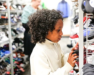 Landen Fitzgerald-Green, 8, looks at shoes in the Burlington store in Boardman during a shopping spree his family received to celebrate his recovery from Leukemia on Thursday. EMILY MATTHEWS | THE VINDICATOR