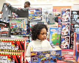 Landen Fitzgerald-Green, 8, looks at toys while his dad Walter Green looks at clothes behind him in the Burlington store in Boardman during a shopping spree his family received to celebrate his recovery from Leukemia on Thursday. EMILY MATTHEWS | THE VINDICATOR