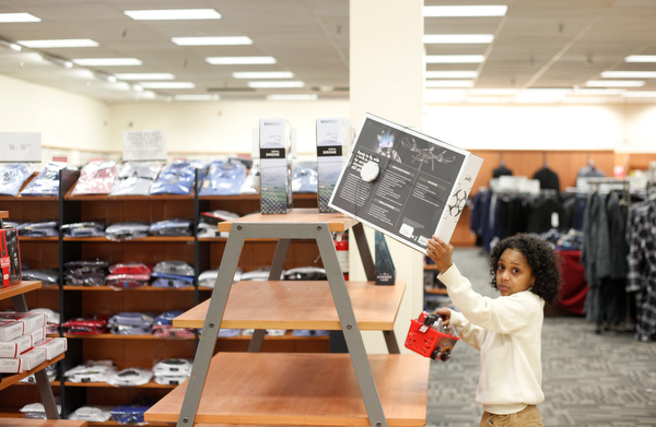 Landen Fitzgerald-Green, 8, takes a drone off the shelf while holding a toy tool set in the Burlington store in Boardman during a shopping spree his family received to celebrate his recovery from Leukemia on Thursday. EMILY MATTHEWS | THE VINDICATOR