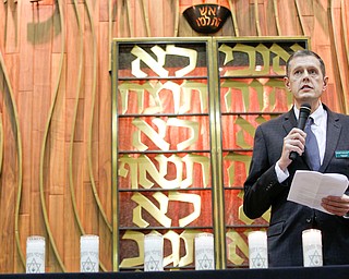 Aaron Hively, President of the Congregation Rodef Sholom, speaks about and lights a candle for Jerry Rabinowitz, one of the victims of the shooting at the Tree of Life Synagogue, during an interfaith vigil for the Pittsburgh Tree of Life Synagogue victims at Temple El Emeth in Liberty on Thursday evening. EMILY MATTHEWS | THE VINDICATOR