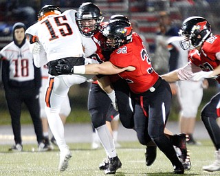 Canfield's Tyler Stein, center, and Chris Sammarone, right, tackle Marlington's CJ Greiner during the first half of their game at Canfield on Friday. EMILY MATTHEWS | THE VINDICATOR