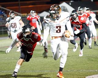 Marlington's Markavien Mason run with the ball as Canfield's Ethan Fletcher runs up behind him during the first half of their game at Canfield on Friday. EMILY MATTHEWS | THE VINDICATOR