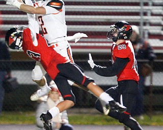 Canfield's Ethan Fletcher reaches up to intercept the ball from Marlington's Blane Himmelheber while Canfield's Jacob Whittenberger watches for the ball during the first half of their game at Canfield on Friday. EMILY MATTHEWS | THE VINDICATOR