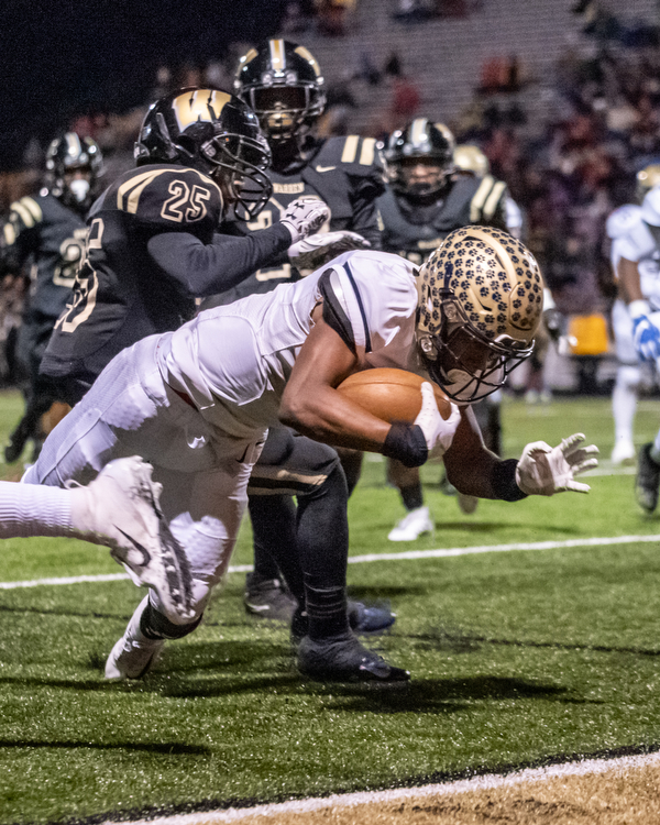 DIANNA OATRIDGE | THE VINDICATOR  Garfield Heights' Isaiah Jackson (1) crosses the goal line ahead of Warren Harding defenders Ty Artis (25) and Jesean Sledge (23) during their first round playoff game at Mollenkopf Stadium in Warren on Friday.