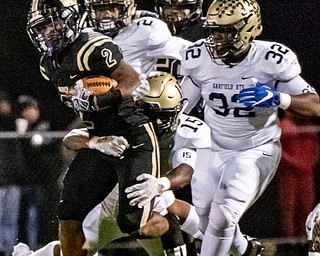 DIANNA OATRIDGE | THE VINDICATOR  Warren Harding's Kayron Adams (2) rushes for yardage with Garfield Heights' defenders Adrian Thompson (2), Donald Willis (15), and Damien Peterson (32)  in pursuit during their first round playoff game at Mollenkopf Stadium in Warren on Friday.