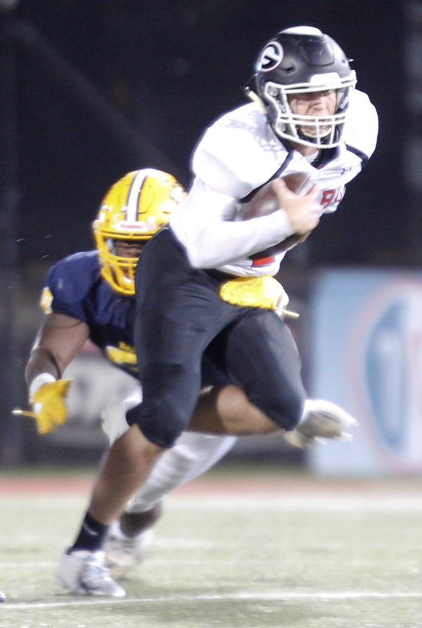 Girard's Mark Waid runs with the ball while East's Terrance Yeboah tries to tackle him during the first half of their game at Stambaugh Stadium on Saturday. EMILY MATTHEWS | THE VINDICATOR