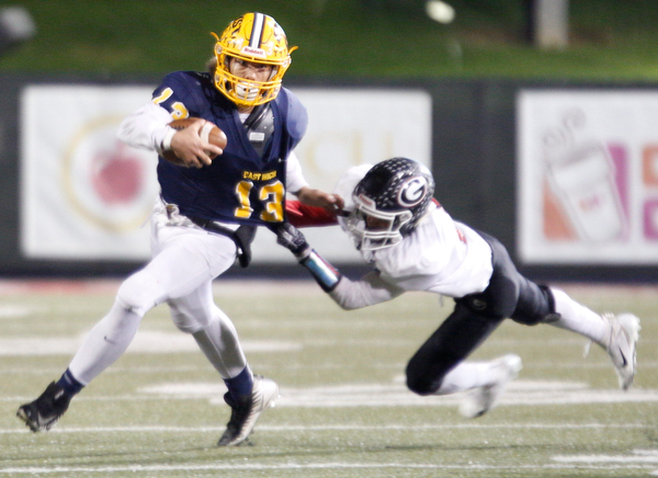 East's Delshawn Petrosky tries to run with the ball as Girard's Morgan Clardy goes in for the tackle during the first half of their game at Stambaugh Stadium on Saturday.  EMILY MATTHEWS | THE VINDICATOR