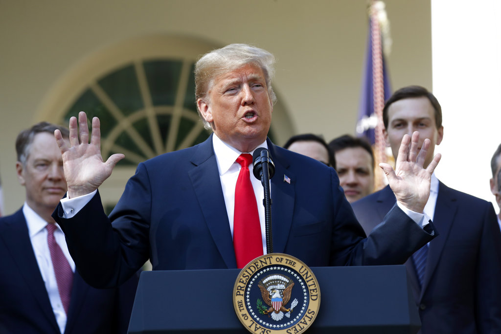 In this Monday, Oct. 1, 2018, file photo, President Donald Trump speaks as he announces a revamped North American free trade deal, in the Rose Garden of the White House in Washington. President Donald Trump insists his new North American trade deal will deliver a victory for U.S. factory workers by returning many high-paying jobs to the United States. Maybe. But a review of the agreement suggests that job gains for the U.S. would likely mean higher prices for consumers and more inefficiencies for businesses. The biggest winners might end up being robots and the companies that make them.