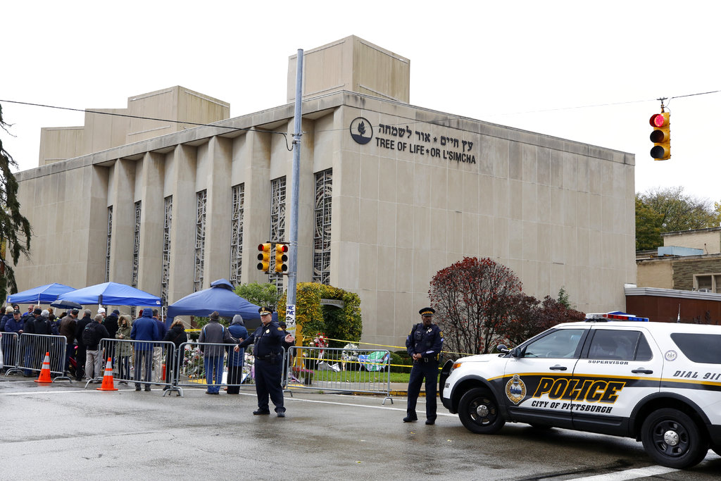 Pittsburgh Police direct traffic as their vehicles close the street adjacent to the Tree of Life Synagogue on Saturday, Nov. 3, 2018, as a curbside Shabbat morning service is held on the street corner in the Squirrel Hill neighborhood of Pittsburgh. The service honored the 11 people killed by a gunman, Oct 27, 2018, while worshipping at the Tree of Life Synagogue.