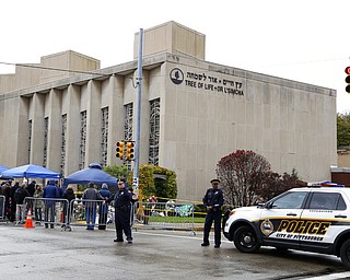 Pittsburgh Police direct traffic as their vehicles close the street adjacent to the Tree of Life Synagogue on Saturday, Nov. 3, 2018, as a curbside Shabbat morning service is held on the street corner in the Squirrel Hill neighborhood of Pittsburgh. The service honored the 11 people killed by a gunman, Oct 27, 2018, while worshipping at the Tree of Life Synagogue.