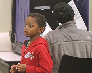 Cord'e Wilson, 5, waits while his mother, Michelle Washington, votes at the Youngstown Public Library polling place on Market Street in Youngstown. 