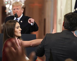 As President Donald Trump points to CNN's Jim Acosta, a White House aide takes the microphone from him during a news conference in the East Room of the White House, Wednesday, Nov. 7, 2018, in Washington.