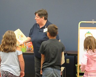 Neighbors | Jessica Harker.Librarian Karen Saunders read a book to children gathered at the Halloween themed story time Oct. 11.