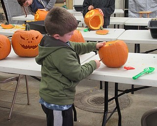 Neighbors | Jessica Harker .Jack Zink carved one of many pumpkins to be put on display at the annual Pumpkin Walk event hosted by Mill Creek Park on Oct. 14.