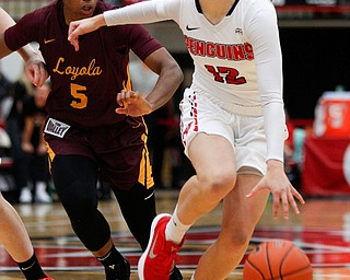 YSU's Chelsea Olson dribbles while Loyola's Tiara Wallace tries to get to the ball during the first half of their game at YSU on Friday night. EMILY MATTHEWS | THE VINDICATOR