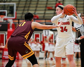 YSU's McKenah Peters looks to pass the ball as Loyola's Janae Gonzales tries to block her during the first half of their game at YSU on Friday night. EMILY MATTHEWS | THE VINDICATOR