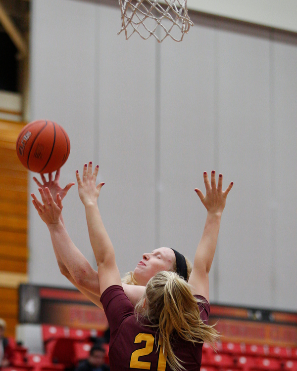 YSU's Sarah Cash tries to shoot as Loyola's Allison Day tries to block her during the first half of their game at YSU on Friday night. EMILY MATTHEWS | THE VINDICATOR